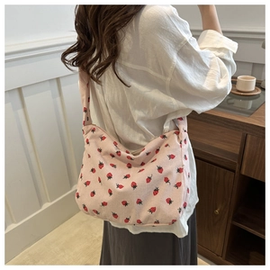 Sac fourre-tout en velours rose avec motif fraise porté par un mannequin en détail