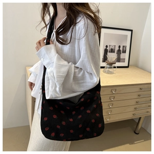 Détail du sac cabas en velours noir avec un motif imprimé de fraises rouges partout