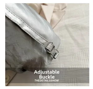 Detail view of the adjustable silver buckle and textured metallic fabric on the tote bag