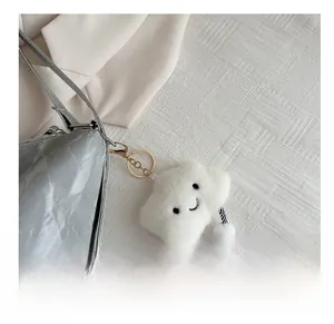 Cute white plush cloud bag charm with embroidered smile and golden ring clasp attachment