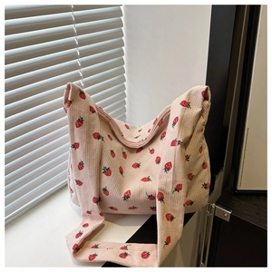 Détail du sac cabas en velours côtelé rose avec motifs fraises rouges et texture douce