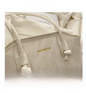 Detailed close-up of beige marble texture tote bag with elegant knot handle and gold logo