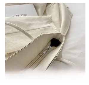 Detail of silver smooth metal zipper on minimalist cream beige shoulder handbag