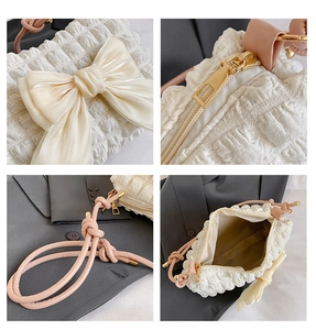 Detailsicht der Blasenstruktur und Seidenschleife auf der rosa Schultertasche