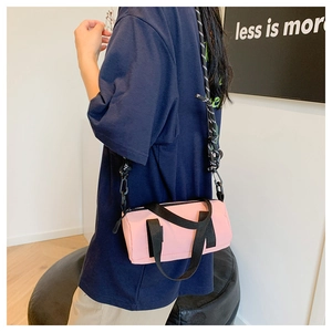 Photo lifestyle d'un sac bandoulière rose en nylon au style sportif et décontracté
