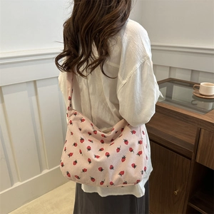 Sac cabas en velours côtelé rose à motif fraises porté par un mannequin style collège