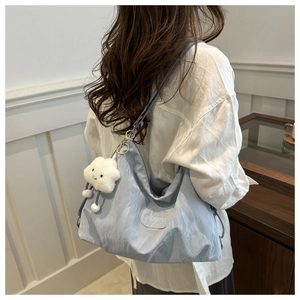 Detail view of light blue tote bag with crinkle texture fabric and cloud charm