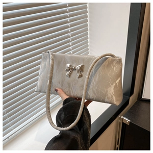 Dettaglio di una borsa a tracolla argento metallizzato con fiocco e trama effetto marmo