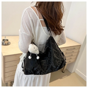 Detail of black pleated hobo bag with plush cloud charm and Jingpin brand patch