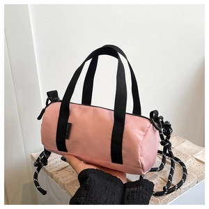 Détail du sac polochon rose avec bandoulière en corde épaisse et poignée en nylon