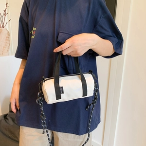 Petit sac polochon blanc avec poignées noires et bandoulière tissée style sac à main