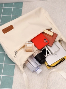 Large white nylon tote bag showing interior storage with iPad, umbrella and daily essentials