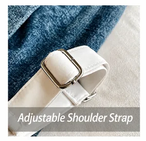 Detail showing adjustable white nylon strap with a square silver metal buckle on bag