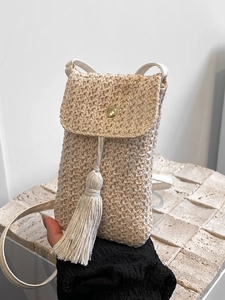Vertical woven straw crossbody phone bag with tassel and gold buckle in beige color