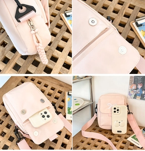 Detail view of pink canvas bag showing white bow embroidery and metallic zipper closure