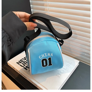 Detail view of mini sky blue canvas crossbody bag with CHINA 01 print and black strap