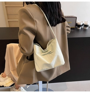 Détail d'un sac cabas en cuir verni vert clair avec un nœud porté par un mannequin élégant