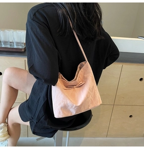 Vue détaillée du sac cabas rose avec nœud papillon et texture plissée à l'épaule