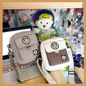 Detail van canvas crossbodytassen met berenpatches in grijs en bruin-witte kleuren