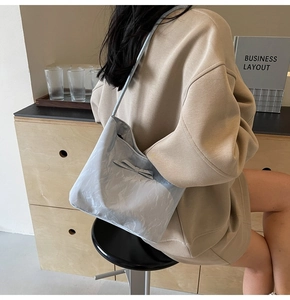 Détail du sac cabas plissé bleu clair avec nœud porté à l'épaule par un mannequin