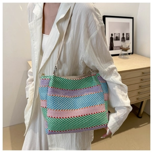 Détail de la texture d'un sac cabas tissé coloré avec bandoulière en cuir et anneau