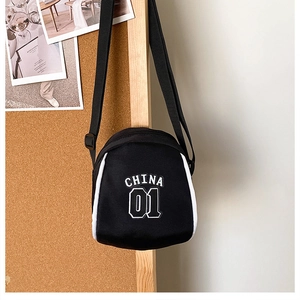 Detail of black canvas mini shoulder bag featuring white piping and CHINA 01 lettering