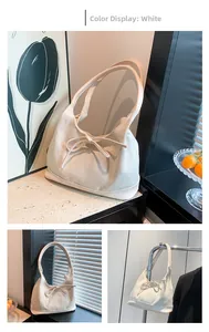 Detail of white tote bag featuring woven herringbone texture and decorative bow knot