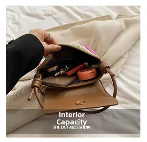 Macro-opname van het ruime interieur van een geweven regenboogtas met mobiel en make-up