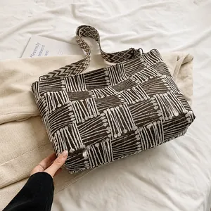 Detail of vintage knit tote bag showing brown geometric jacquard pattern and texture