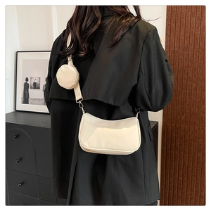 Dettaglio borsa a tracolla in nylon beige con custodia rotonda e cinturino sul modello