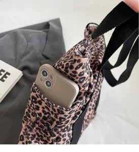 Leopard print tote bag detail showing large front pocket functionality for mobile phones