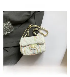 Détail de la broderie à rayures colorées sur sac à rabat matelassé blanc et fermoir doré