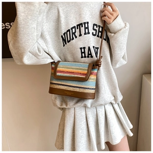 Detail van veelkleurige geweven crossbodytas met strepen en leren bodem