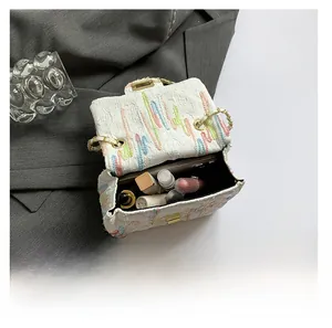 Vue intérieure montrant la capacité du sac en tweed blanc à rayures colorées et chaîne
