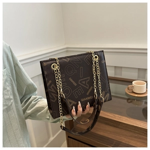 Detalle del bolso bandolera de cuero marrón oscuro con estampados de letras vintage