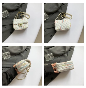 Détails du sac matelassé blanc avec broderies colorées et bandoulière en chaîne dorée