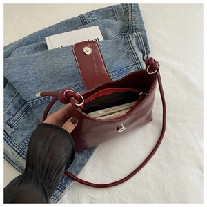 Detail view of dark red shoulder bag interior showing magnetic closure and storage space