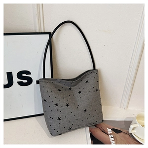 Detail of grey star pattern shoulder bag with sleek black leather strap on minimalist background