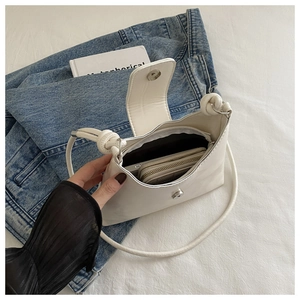 Interior detail of white bow-tied shoulder bag showing space for phone and wallet