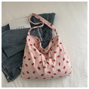Gros plan détaillé du sac cabas en velours côtelé rose avec imprimé fraises rouges