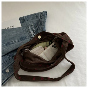 Sac cabas en velours côtelé marron à cœurs montrant l'intérieur spacieux et les objets