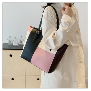 Detail of color-block patchwork tote bag worn over a beige trench coat for daily styling