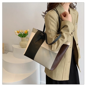 Detailed close-up of a large color-block leather tote bag with elegant geometric patchwork
