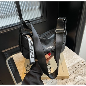 Détail du sac hobo en cuir noir grainé avec bandoulière et étiquette tendance