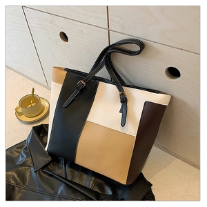 Detail of multi-color patchwork faux leather tote bag with contrast stitching