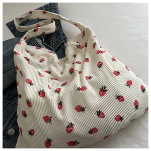 Texture détaillée du sac fourre-tout en velours côtelé blanc à imprimé fraise