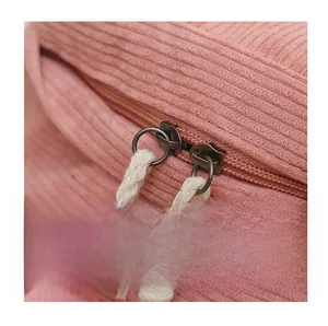 Détail du sac à dos en velours rose avec doubles fermetures éclair et tirettes tissées