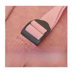 Détail de la bandoulière réglable avec boucle noire sur le sac à dos en velours rose