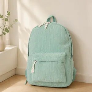 Detailed view of mint green corduroy backpack with front zipper pocket and soft texture
