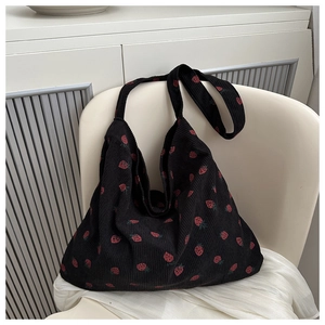 Vue détaillée du cabas en velours côtelé noir avec motif fraise et texture